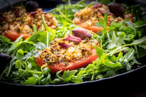 Tomatenscheiben mit griechischem Salat auf Ruccola Salat und Oliven